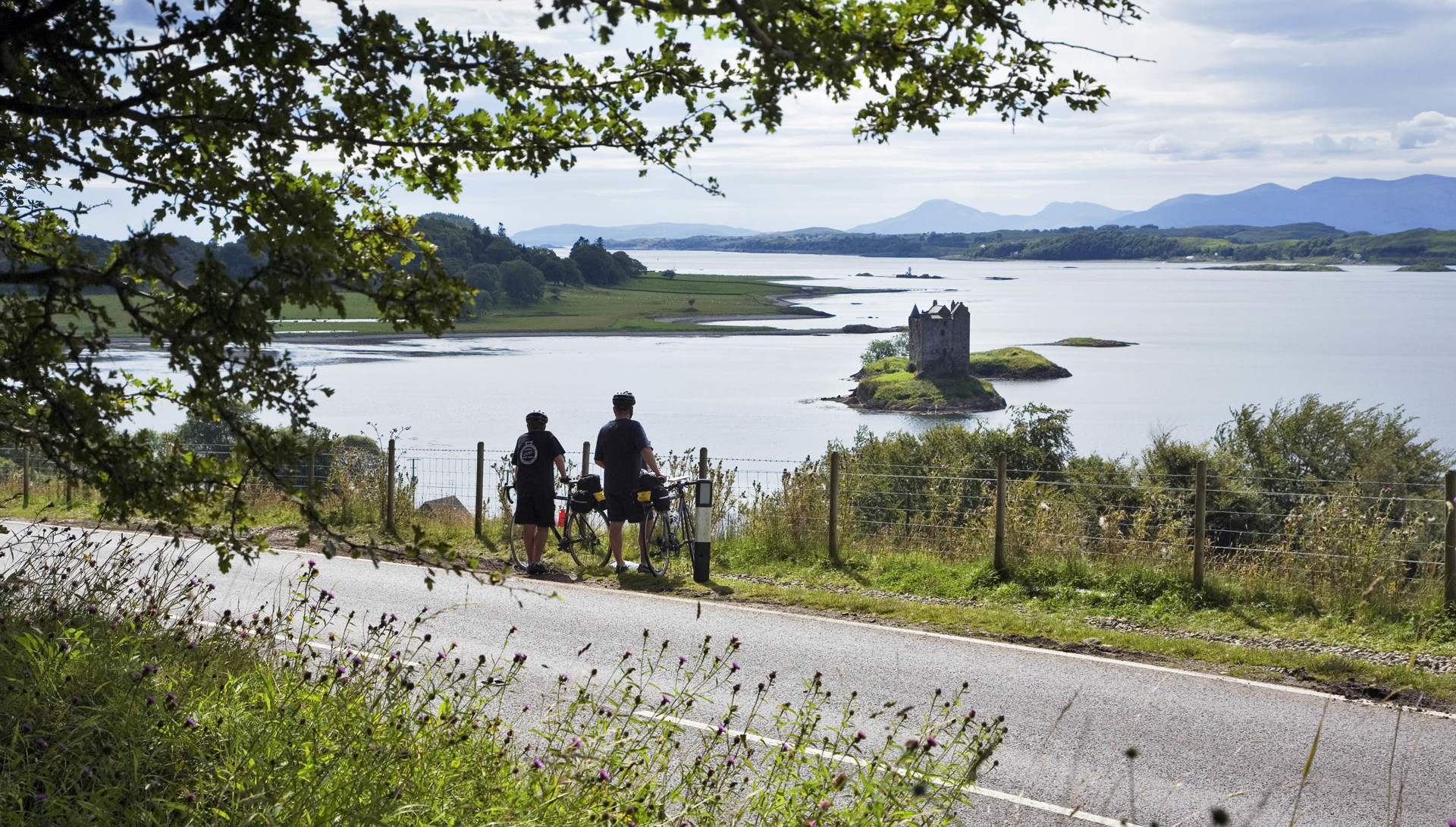 Cyclists At Castle Stalker Scottish Viewpoint